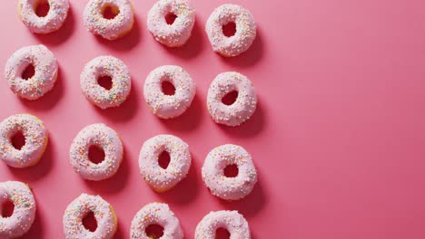 Video-of-donuts-with-icing-on-pink-background
