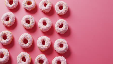 video of donuts with icing on pink background