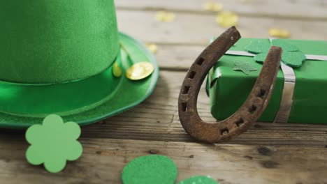 driehoeken en groene hoed met hoefijzer over munten met kopieerruimte op een houten tafel