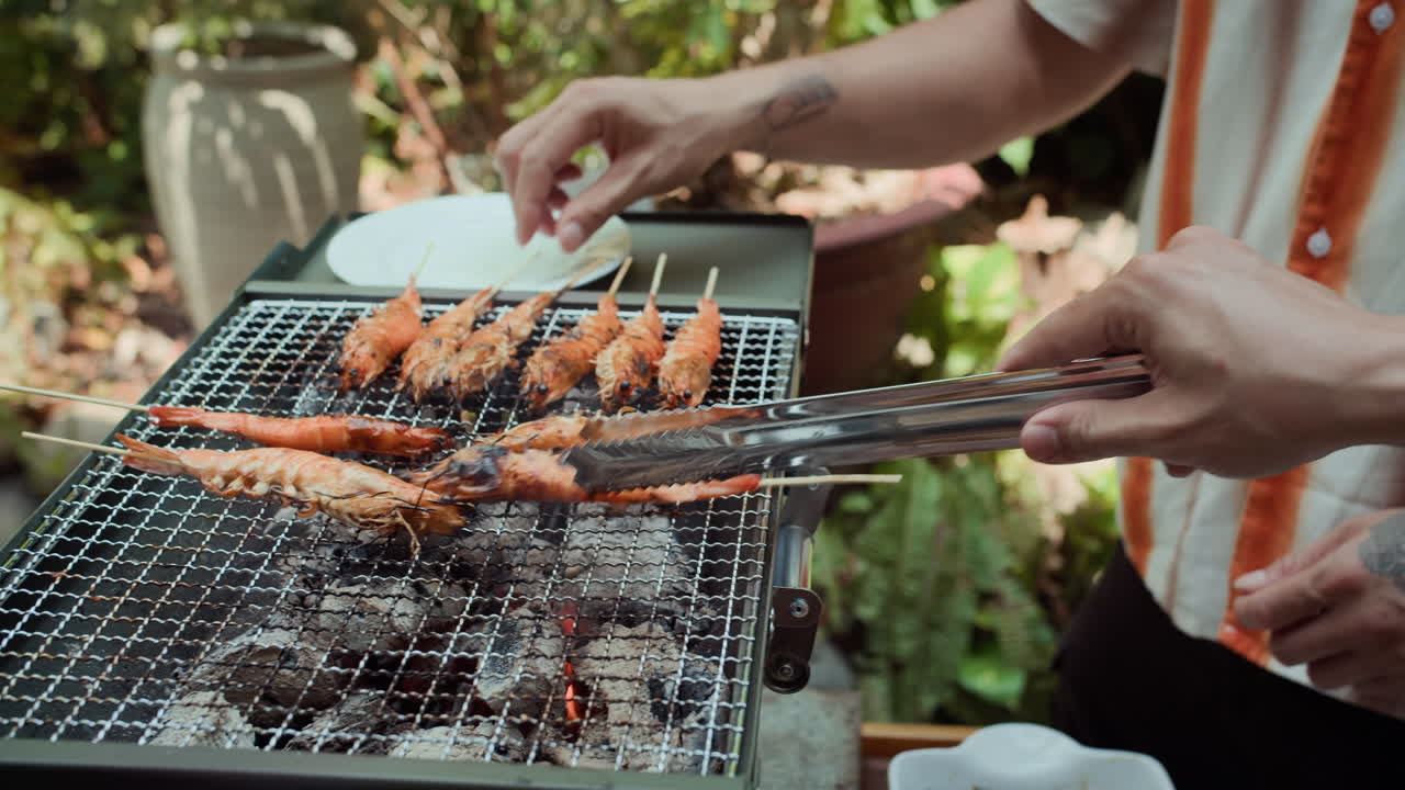 Unrecognizable Men Preparing Shrimps on Grill Outdoors