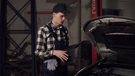 car service technician using digital tablet to examine the vehicle insides. car repair, maintenance, people concept.