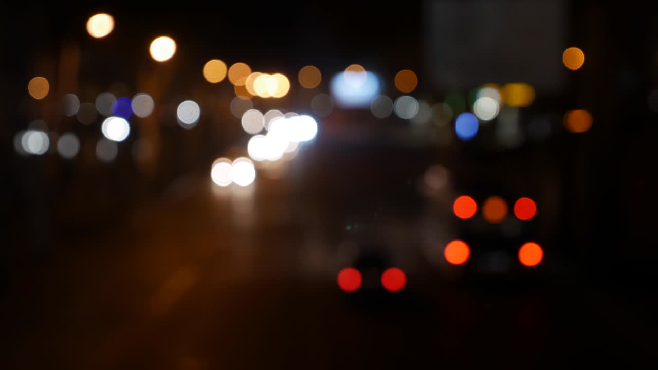 hermoso bokeh brillante en el fondo oscuro borroso por la noche. el redondo bokeh colorido brilla de las luces de los coches en la calle de la ciudad. fuera de foco con borroso. luces de la ciudad sin enfoque. bokeh de tráfico. concepto abstracto