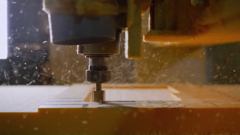 focused shot of a cnc machine carving into foam, with shavings flying around