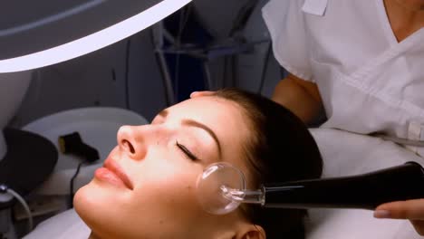 Doctor-performing-laser-hair-removal-on-patient-face