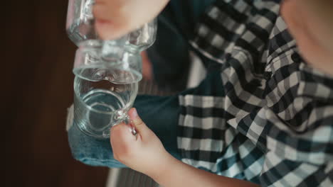 child pouring water into a glass