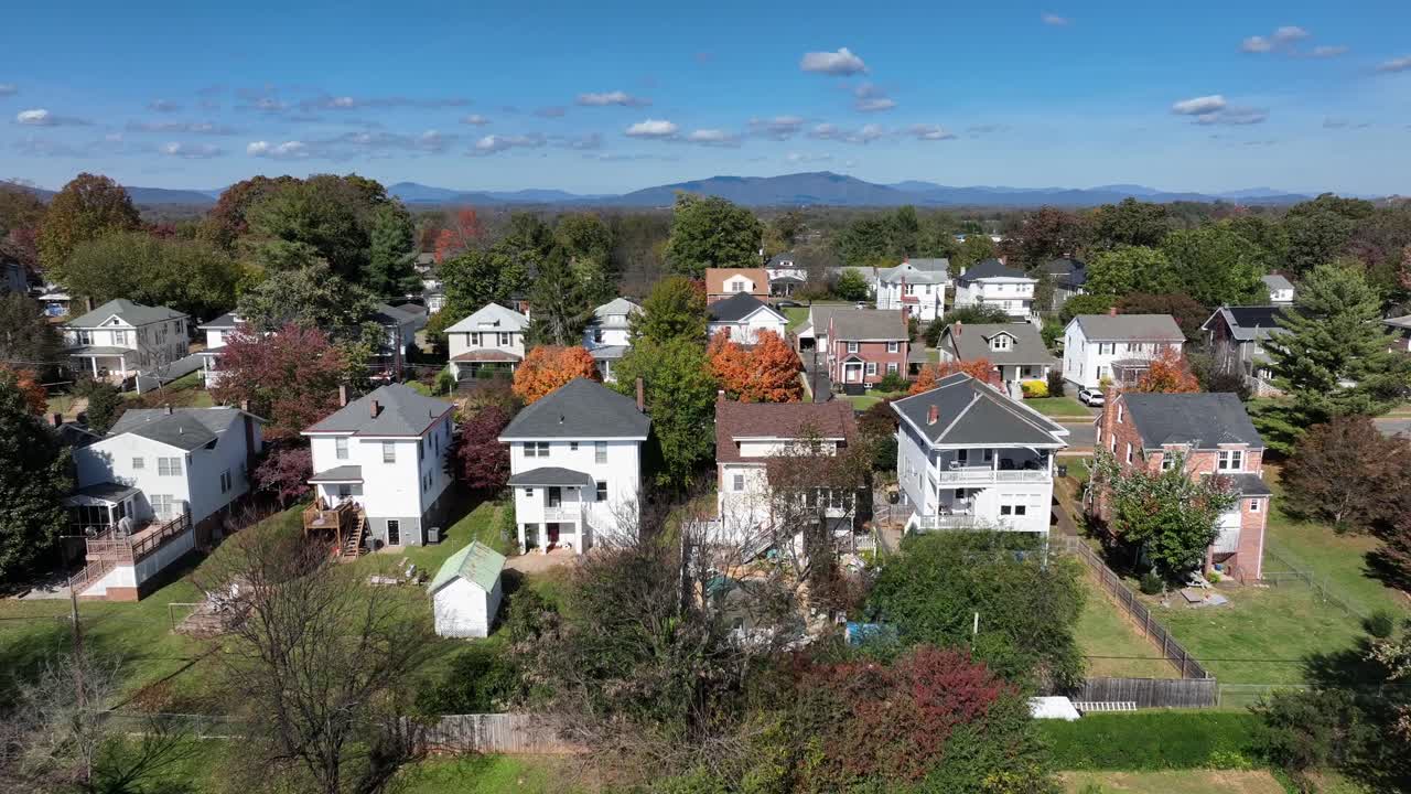 Aerial flyover neighborhood with single family houses in America. Sunny day with colorful trees in autumn season. Community with houses and homes. Massachusetts, USA. Wide shot.