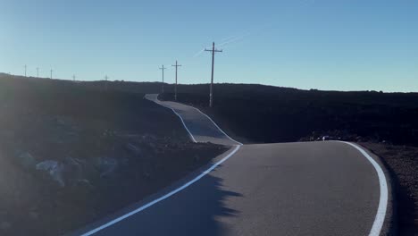 sunset on winding mauna loa access road with telegraph poles