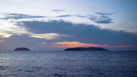 Silueta-De-Las-Islas-Sulug-Y-Manukan-Al-Atardecer-Sobre-El-Mar-Con-Nubes-Bajas-Esponjosas-En-Malasia