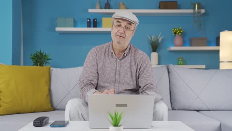 Old man looking at laptop applauds and congratulates.