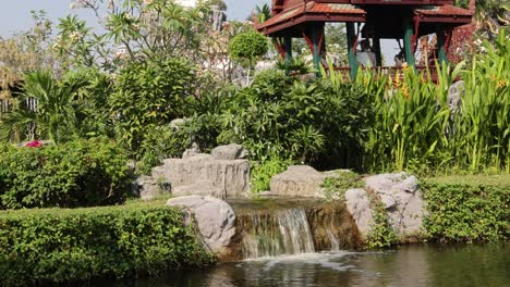 a tranquil garden with a waterfall and pavilion