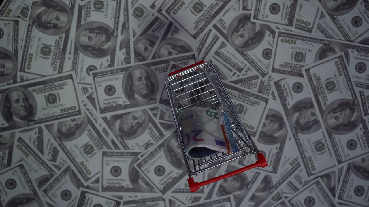 Top of euros in a shopping cart on a stack of dollars