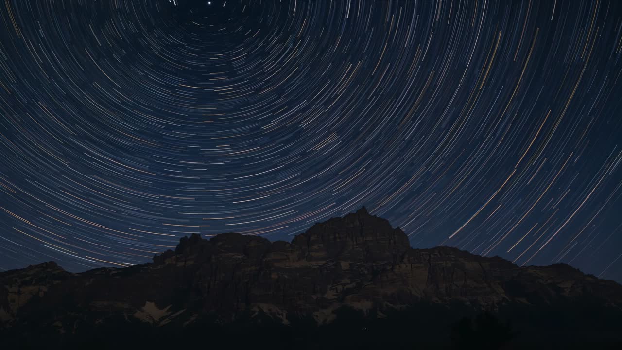 Cámara de lapso de tiempo capturando cresta de noche, formando estelas de estrellas concéntricas para registrar movimiento.