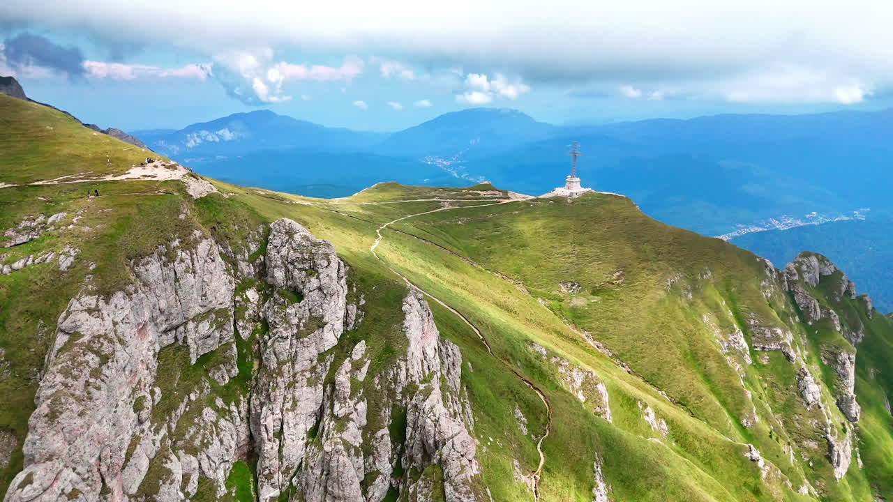 Stunning mountain trails. A panoramic view of rugged mountain terrain featuring winding trails and lush greenery under a cloudy sky