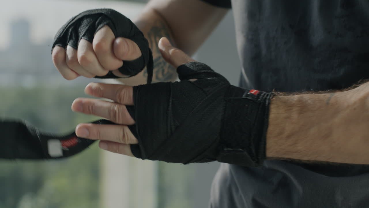 Man preparing for boxing by wrapping his hands