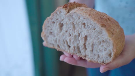 Hände-Halten-Die-Hälfte-Eines-Brotlaibs,-Nahaufnahme