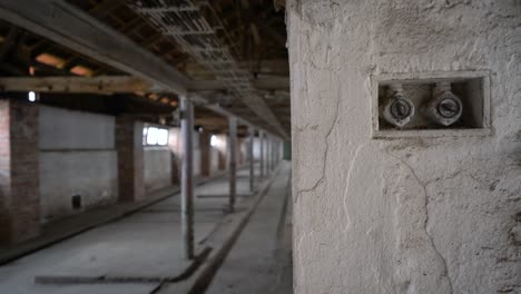 viejos interruptores de luz en una pared sucia en un edificio industrial abandonado, camión de mano lento a la izquierda