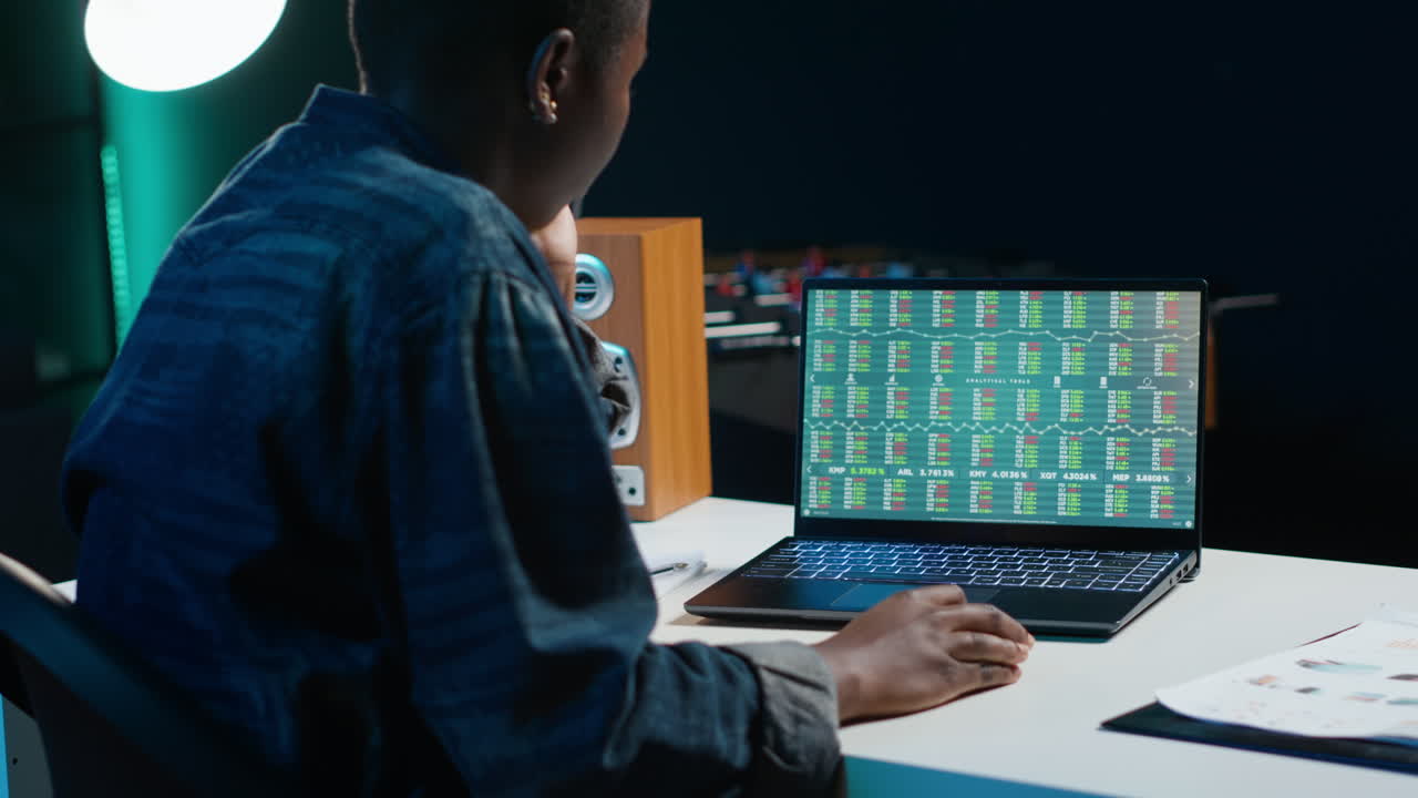 Donna che analizza dati finanziari sul laptop di notte