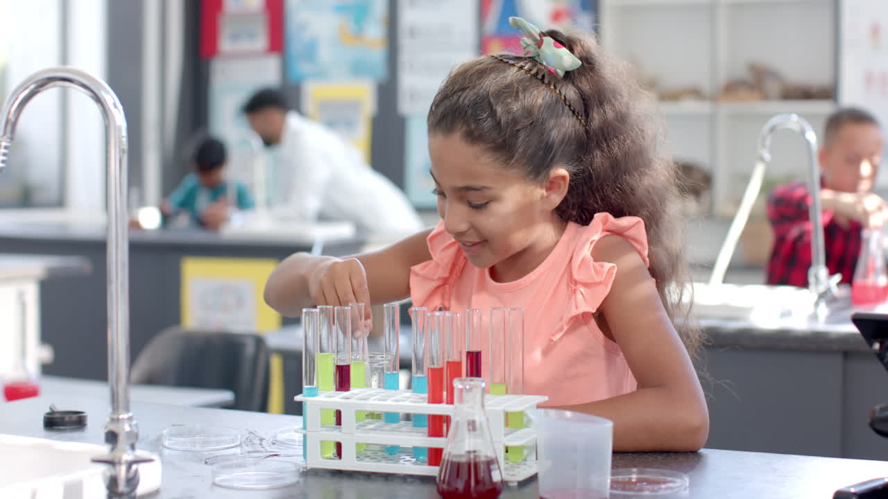 In a school laboratory, a young biracial girl is focused on her science experiment