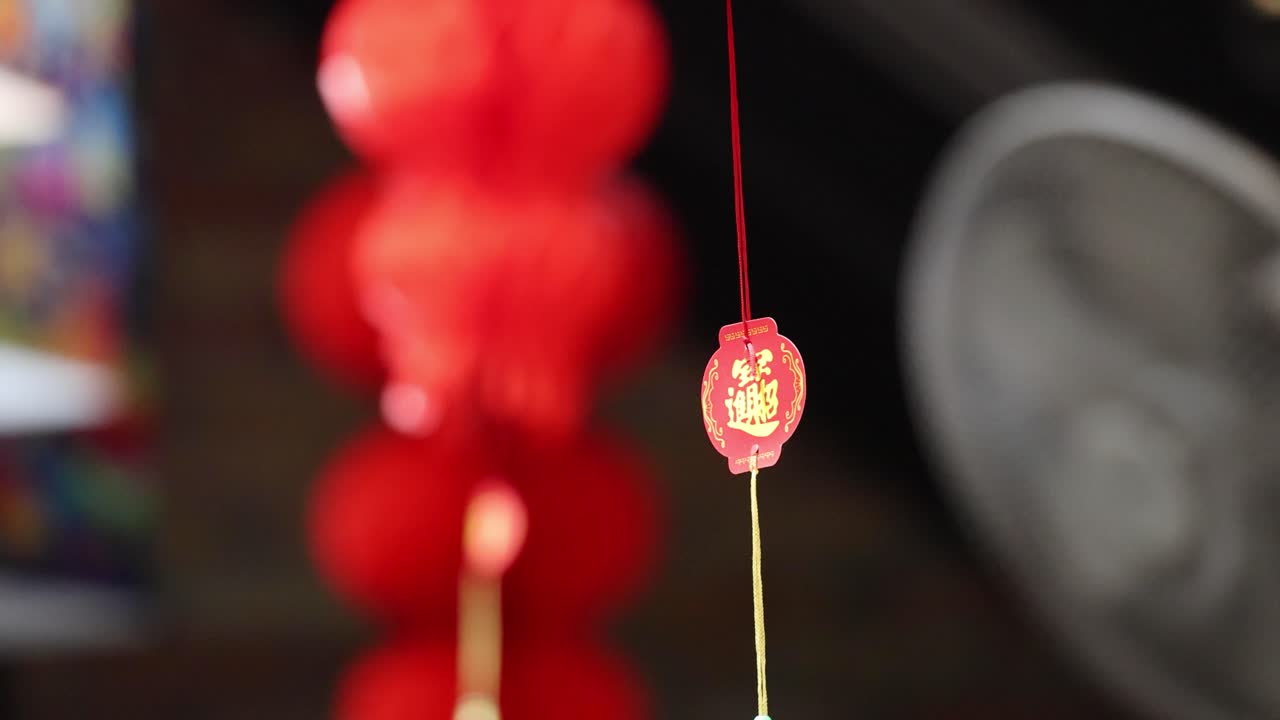 Red lanterns gently swaying in the breeze, captured in vibrant detail against a blurred background in Phuket, Thailand