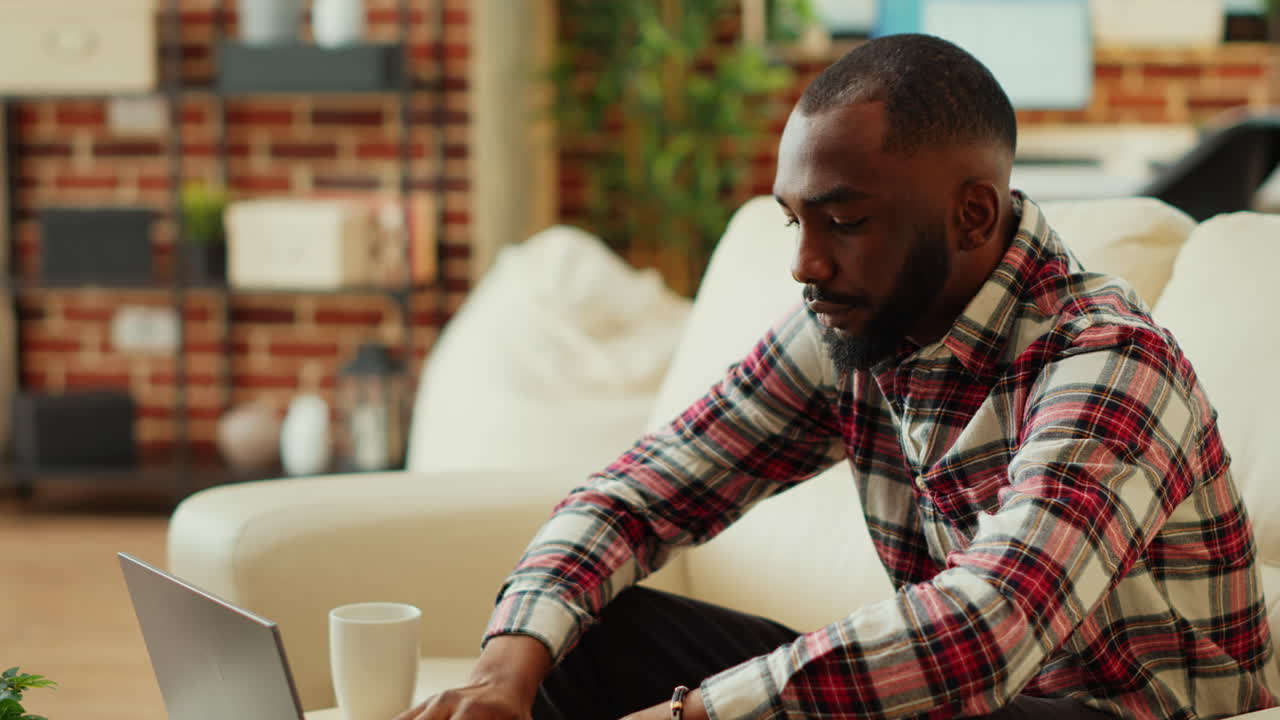 Man using laptop on couch at home