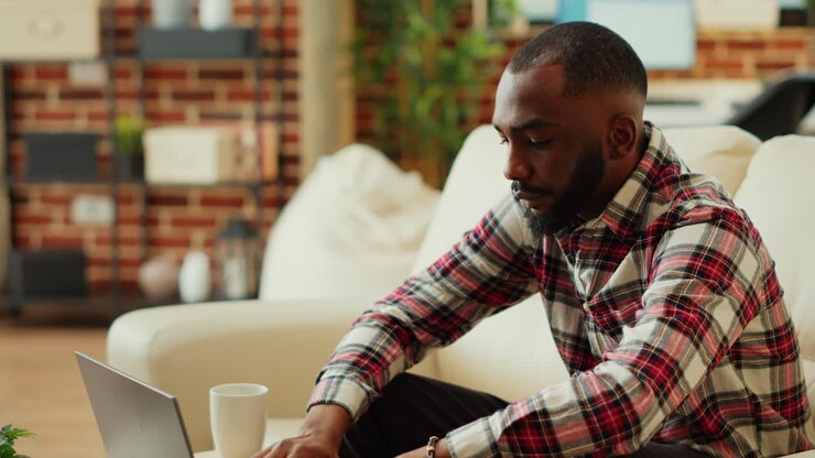 Man using laptop on couch at home