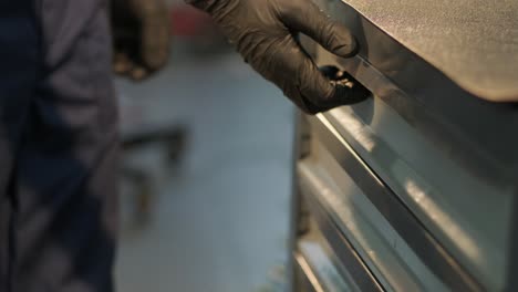 mechanic open blue metal box with different tools for car repair at modern service station