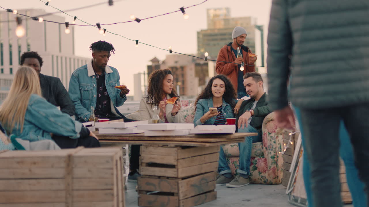 행복한 옥상 파티 친구들이 술을 마시고 주말에 즐겁게 지내고 사회적 모임에서 대화를 나누고 피자를 나누고 해가 지는 날 함께 어울리는 것을 즐기고