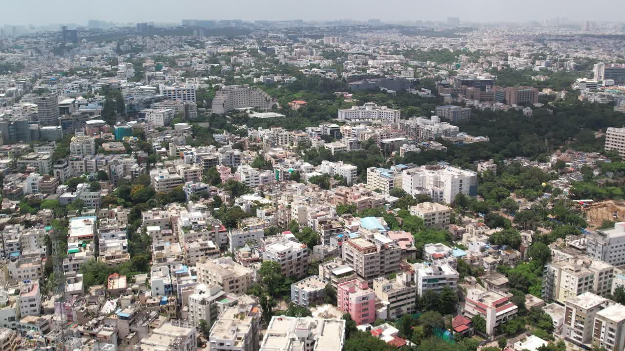 imágenes cinematográficas aéreas de una ciudad en la india muestran edificios y árboles paralelos a las vías del ferrocarril y una estación de metro en el centro de la ciudad