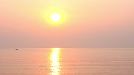 a dramatic pink and orange tropical sunset over the ocean waves