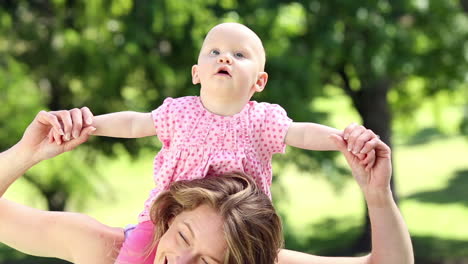 madre feliz jugando con su niña en el parque