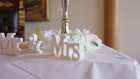 close-up of 'mr and mrs' wedding table decoration with white flowers and centerpiece