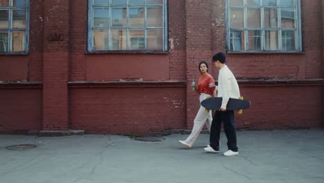 couple walking and skateboarding