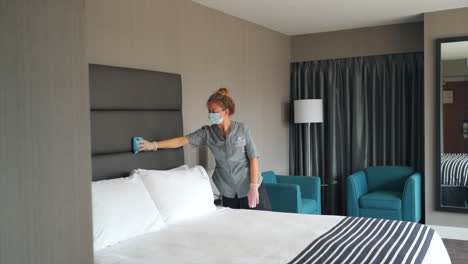 la criada realiza sus tareas de manera eficiente, ordenando la habitación del hotel con precisión y cuidado, limpiando y limpiando todo en una habitación de hotel