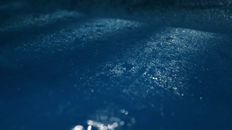 a serene water surface with gentle ripples and glistening raindrops in calming blue hues, creating peace