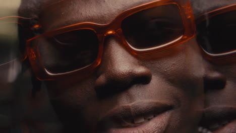 kaleidoscopic effect of handsome black man in sunglasses smiling at camera