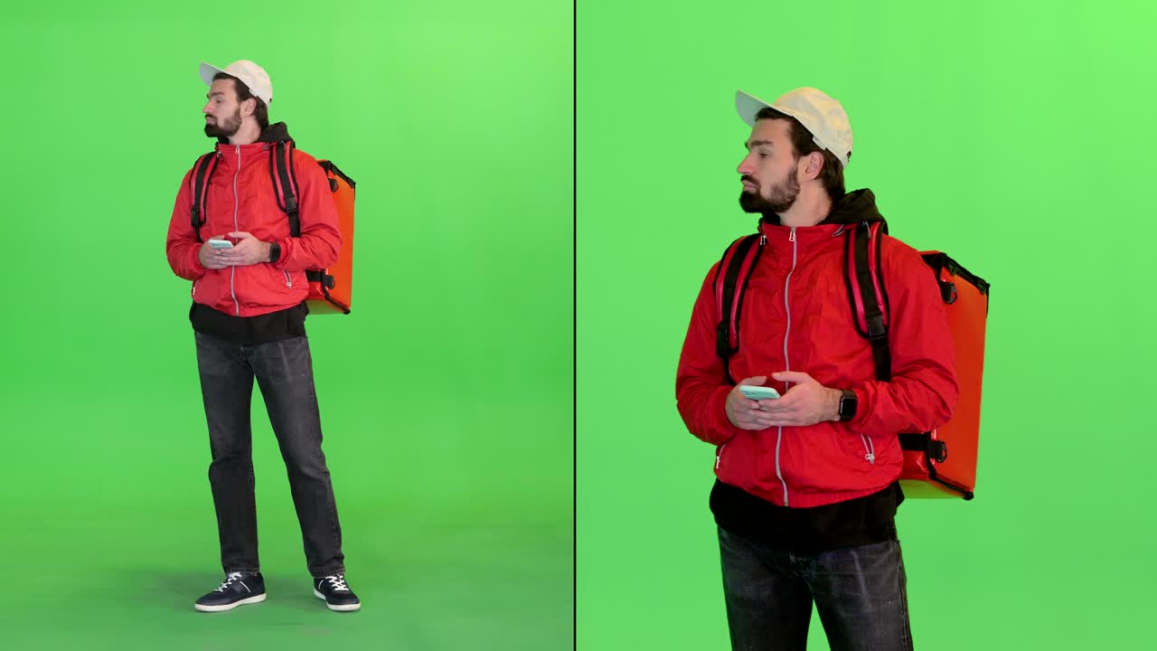 Delivery man with backpack got lost and looking at his phone on a Green Screen, Chroma Key
