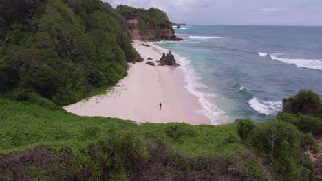 captura reveladora de la playa de mbawana isla de sumba con un hombre caminando sobre arena blanca, aero