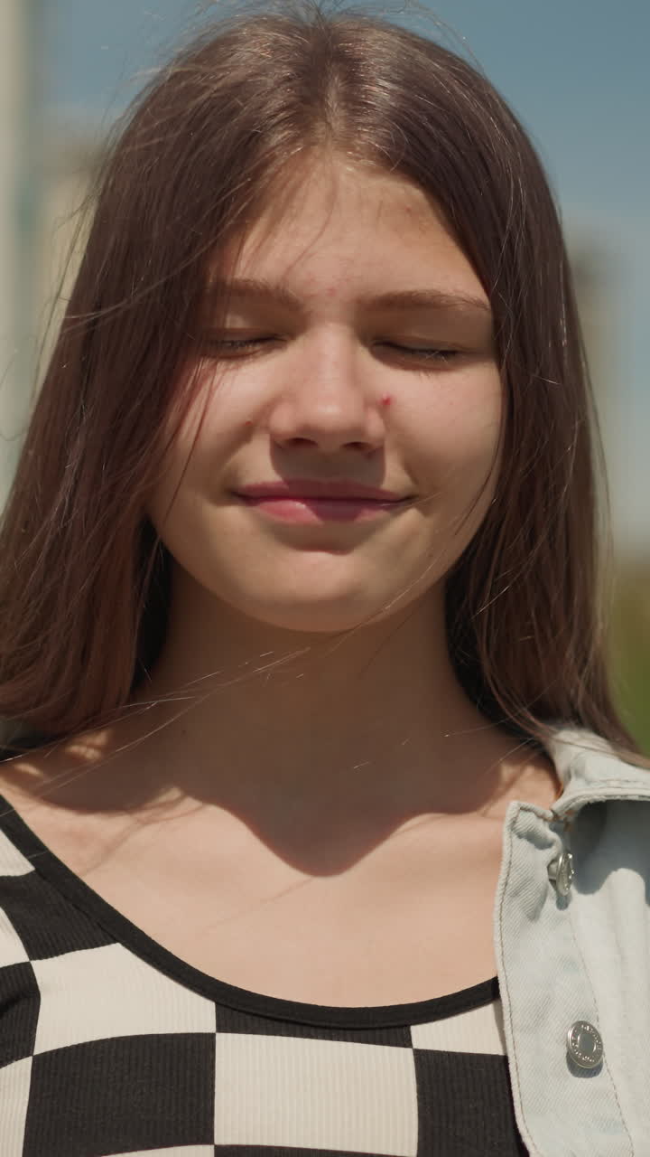 la niña se encuentra cerca de un edificio de gran altura cerrando los ojos soñadoramente. el adolescente fantasea sobre antiguos eventos heroicos sonriendo felizmente de cerca en un fondo borroso
