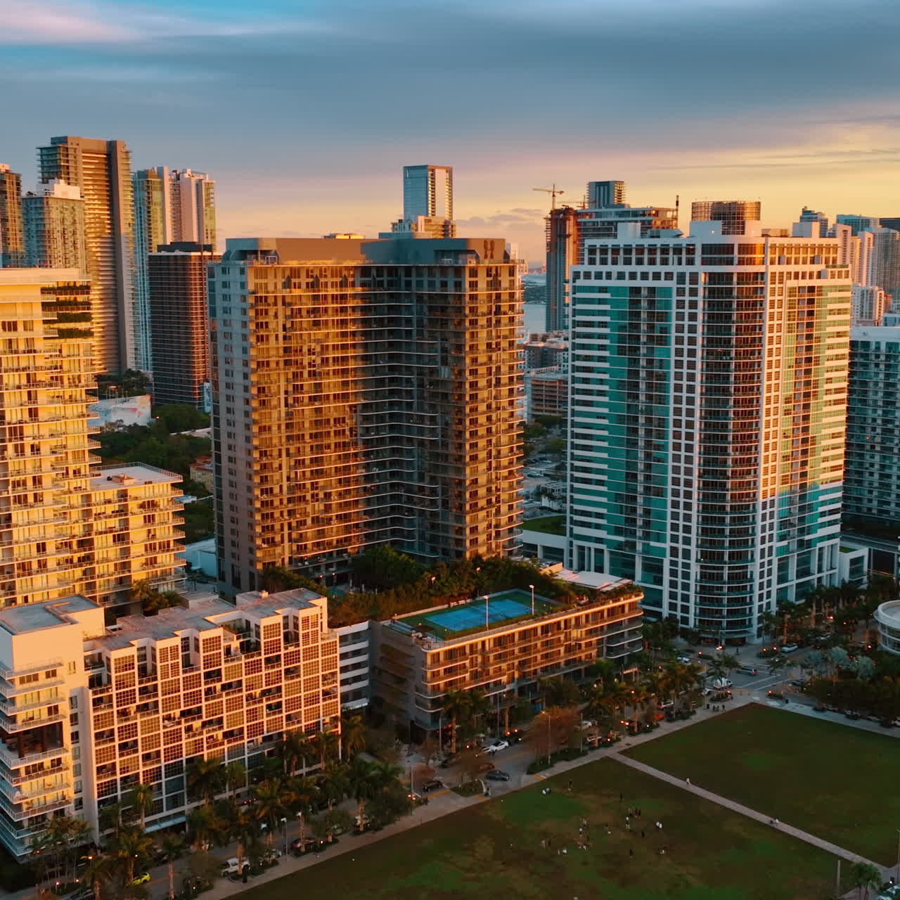 Bright orange light of setting sun on the facades of the high-rise ...