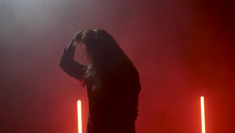 Woman-standing-in-the-fog-on-a-stage-and-presenting-herself-in-slow-motion