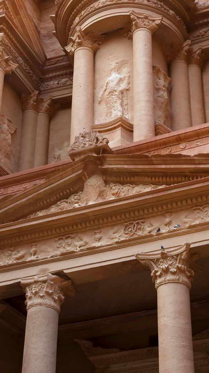 Gli intagli del Tesoro di Petra rivelano ornate colonne in pietra e facciate in Giordania, panoramica verticale verso l'alto