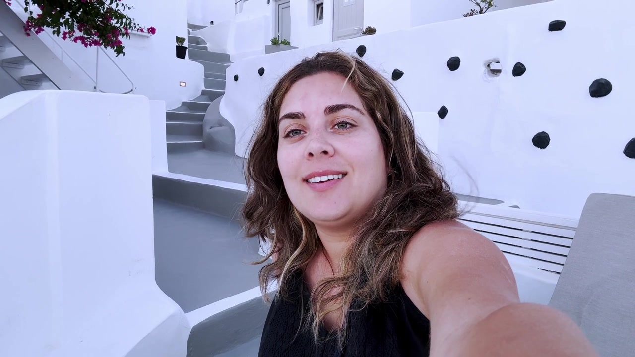 Influencer che fa vlogging mentre registra un video selfie a Santorini, Grecia.