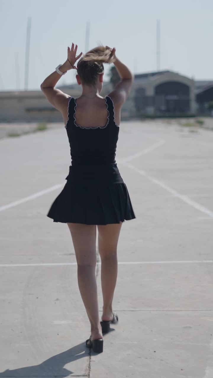 Woman in black dress walking on concrete