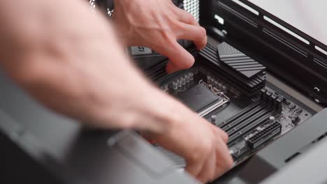 hombre colocando una placa base en un caso de computadora