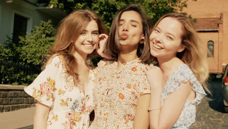 three happy friends posing outdoors