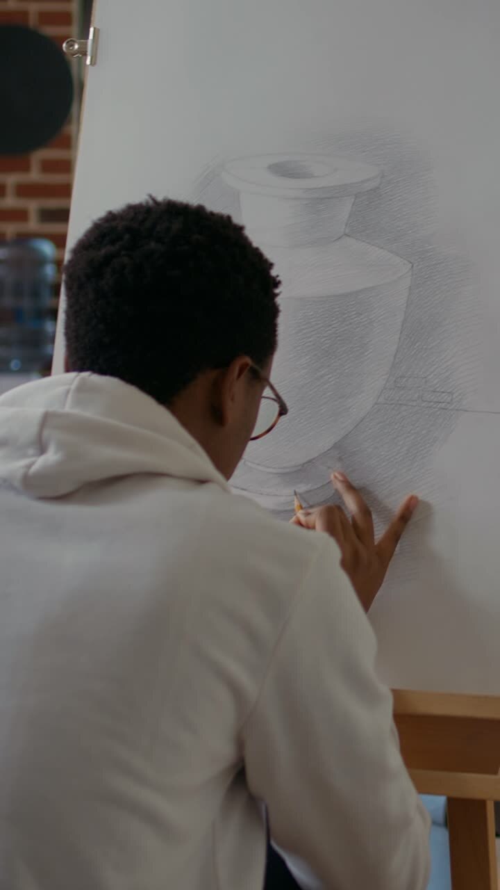 Student photographing a still life drawing in art class