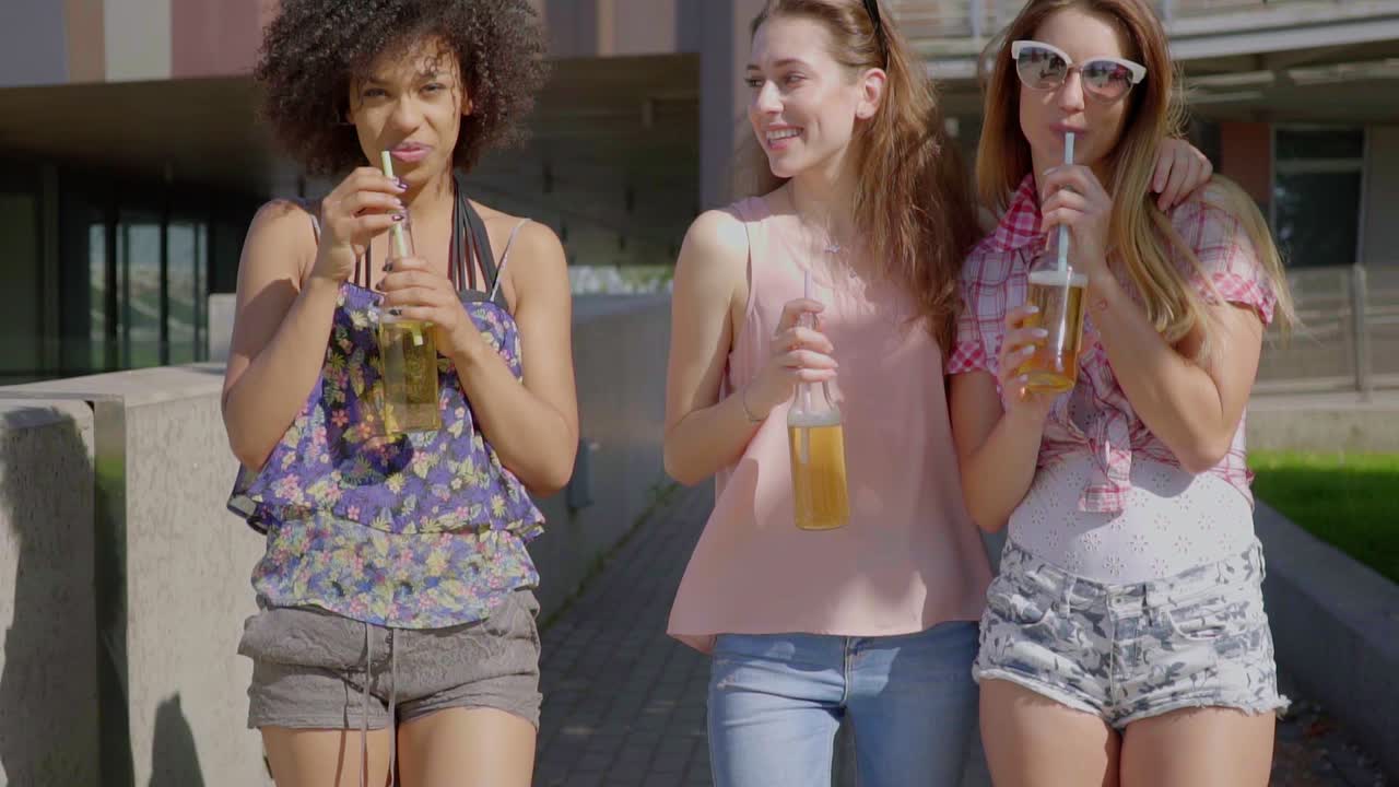 mujeres caminando y tomando cerveza