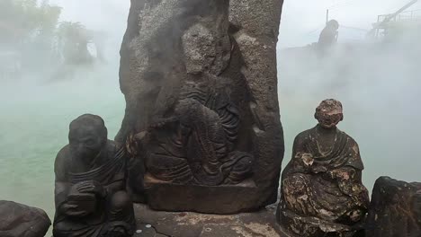 viejas estatuas erosionadas frente a un manantial geotérmico en japón
