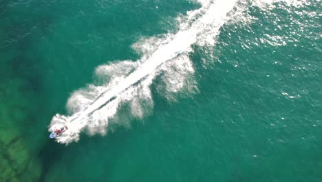 a short shot of a tourist riding a water scooter, aerial view