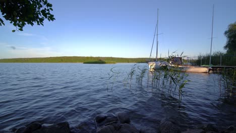 Veleros-Y-Un-Pequeño-Muelle-En-La-Orilla-Del-Gran-Jezioro-Ostrowieckie-En-Pojezierze-Zninskie-En-Verano,-Polonia